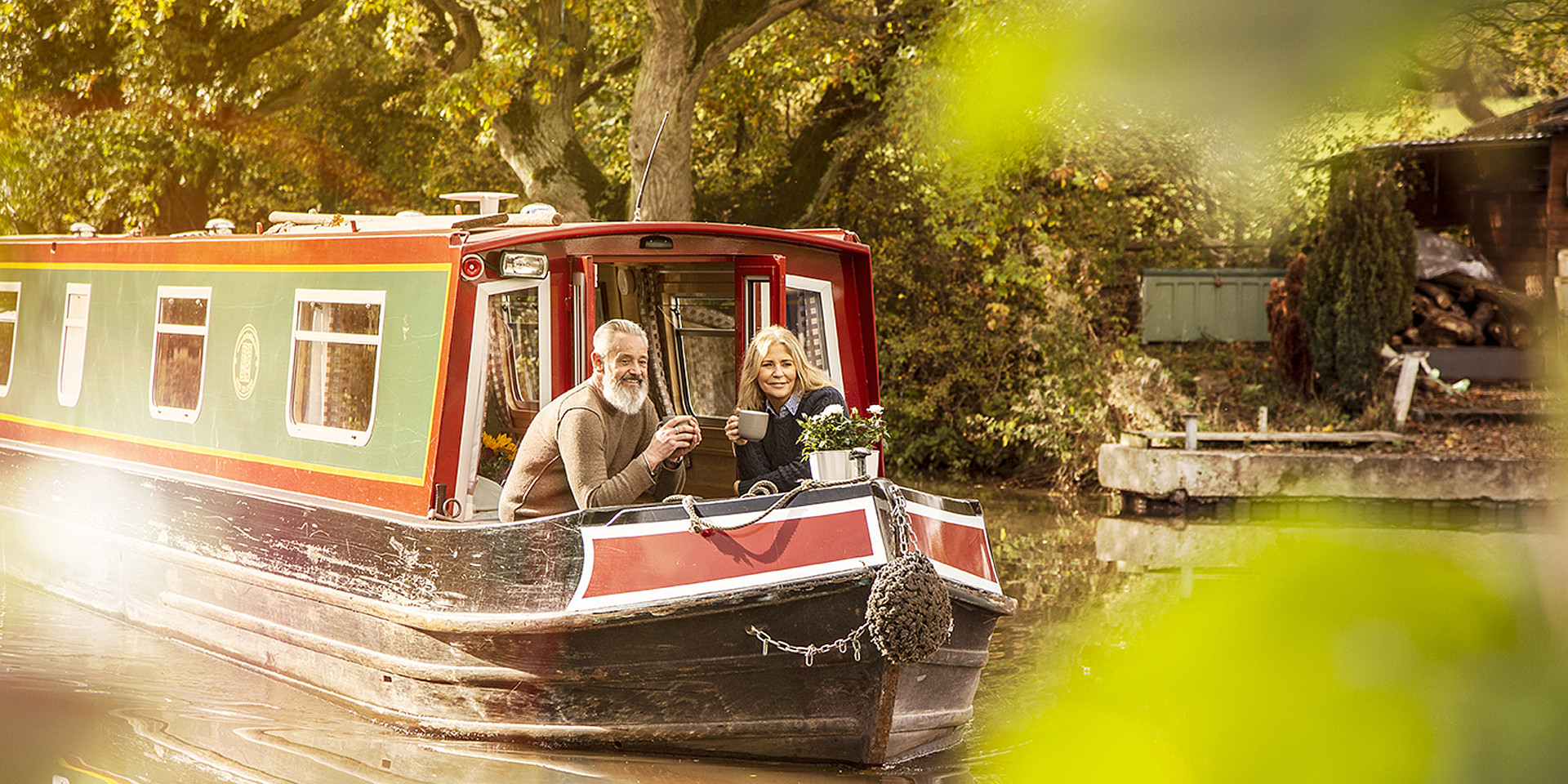 Ein Paar genießt die entspannte Fahrt im Hausboot auf dem Kanal. ©England's Waterways