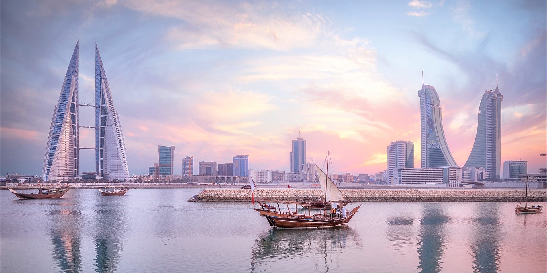 Traditionelles Fischerboot vor der Skyline von Manama mit dem Bahrain World Trade Center auf der linken Seite © BTEA