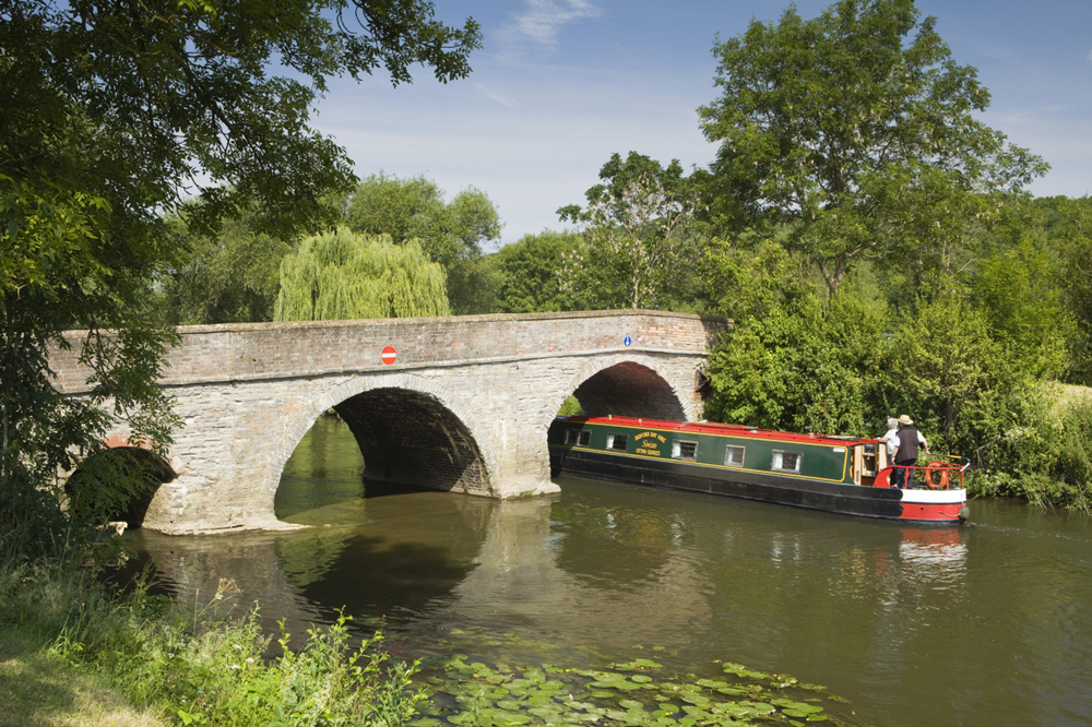 Ein typisch englisches Narrowboat durchfährt eine Brücke auf dem Fluss Avon. ©VisitBritain/LeeBeel