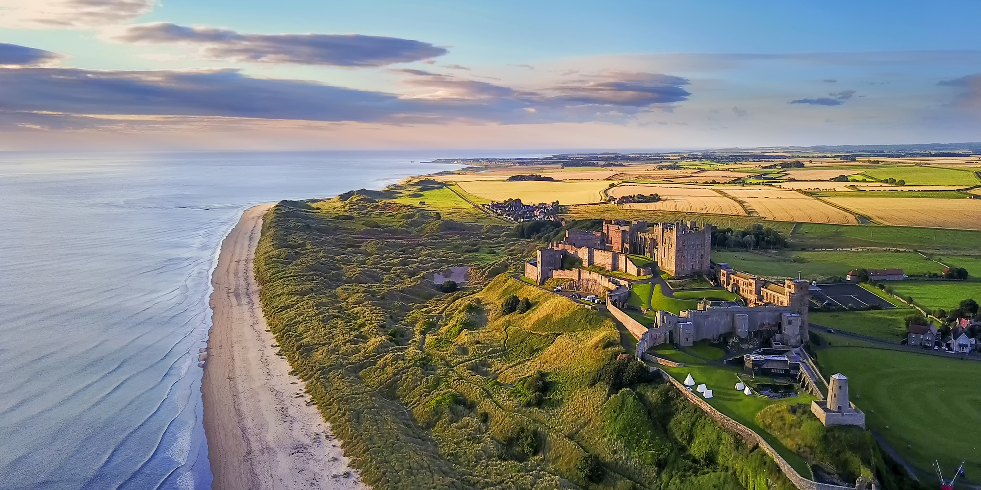 Bamburgh Castle an der Küste von Northumberland aus der Vogelperspektive. © VisitBritain/Yin Sun Photography